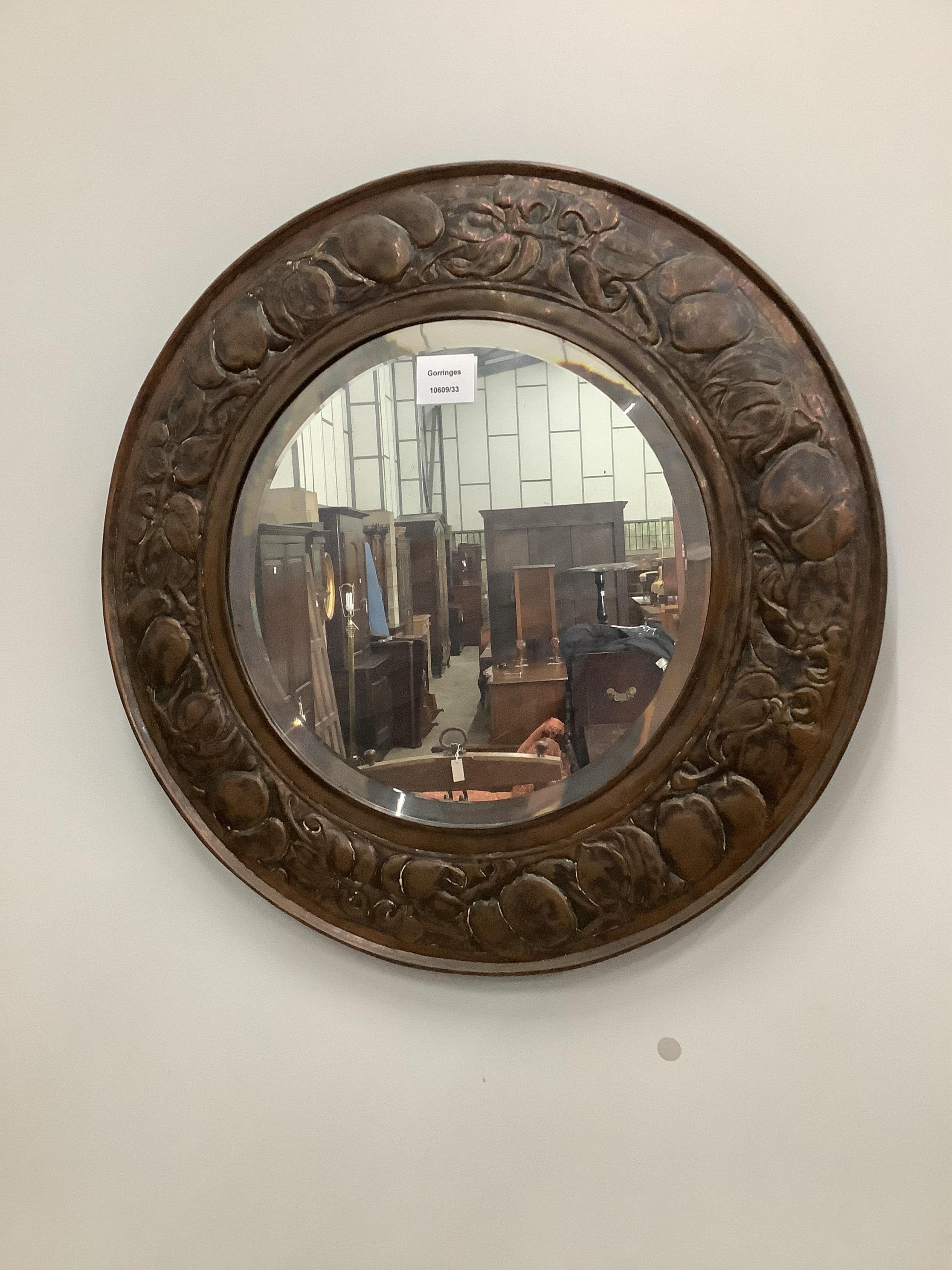 An Arts & Crafts circular embossed copper wall mirror, diameter 54cm. Condition - fair